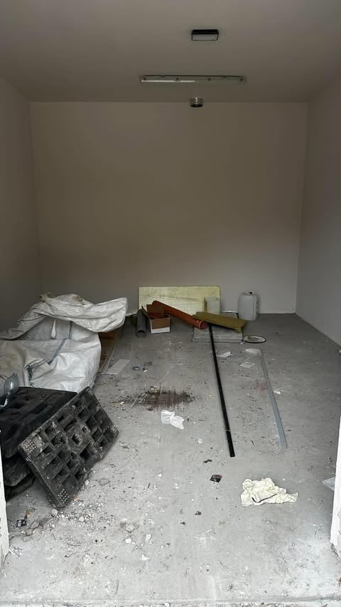 Puste pomieszczenie w trakcie remontu z betonową posadzką i materiałami budowlanymi